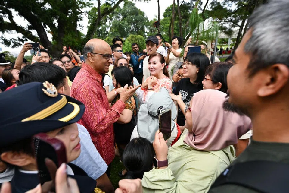 PresidenTharman Shanmugaratnam (berbaju merah) beramah mesra dengan pengunjung di Taman Jepun di pekarangan Istana semasa Rumah Terbuka Istana sempena Tahun Baru Cina pada 2 Februari.