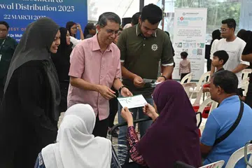 Menteri Negara (Ehwal Dalam Negeri merangkap Pembangunan Negara), Profesor Madya Dr Muhammad Faishal Ibrahim (berdiri, dua dari kiri) bersama Presiden Persatuan Muhammadiyah, Ustaz Muhammad Azri Azman (berdiri, tiga dari kiri), dan Setiausaha Umum Muhammadiyah, Cik Roszanah Abdul Salim (kiri), menyampaikan zakat kepada golongan yang memerlukan. 