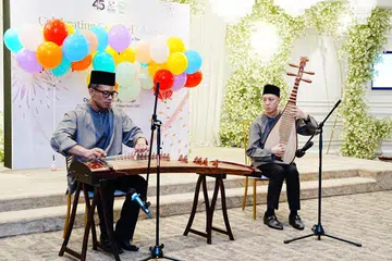 Encik Mohamed Faizal Mohamed Salim (kiri) bersama Encik Chin Yen Chien mempersembahkan tiga lagu dengan alat muzik tradisional Cina Guzheng dan Pipa semasa Perhimpunan Pertengahan Tahun Kelab Berbilang Negara Darul Arqam Singapura pada 20 Julai.