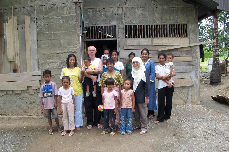 Cik Juliah Bee (berbaju biru, tiga dari kanan) dirakam di Meulaboh, Aceh, pada Oktober 2005 bersama penduduk Meulaboh serta pengurus projek pembangunan Aceh Mercy Relief, Encik Edward John Langton (empat dari kiri).