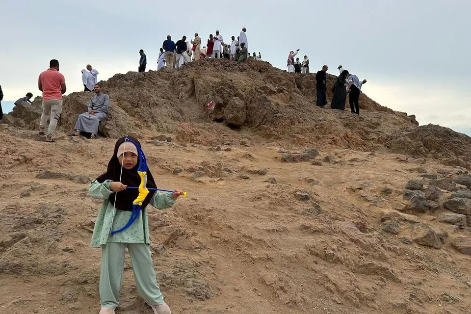 Nur Safiyyah Sallahuddin memegang alat memanah di Bukit Uhud.