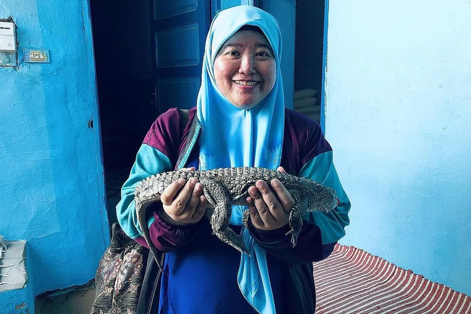 ANAK BUAYA 'PENJAGA' DESA: Masyarakat Nubian yang dipanggil 'crocodile whisperer' kerana boleh berbual dengan buaya, memelihara haiwan itu (dipegang penulis) sebagai satu tradisi zaman-berzaman.- Foto BH oleh HARYANI ISMAIL