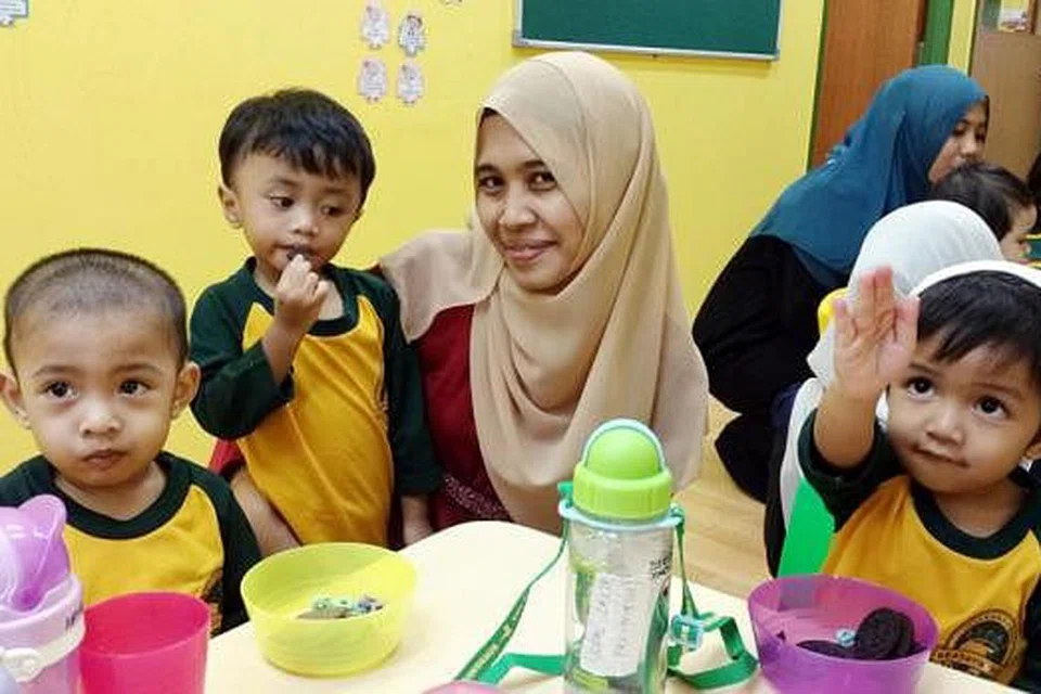 JAGA AMANAH SEBAIK MUNGKIN: Cikgu Siti Sarah Md Sani yang kini mengandung perlu menjaga kebajikan dirinya, anaknya Seth Al-Aadel (yang didukung), serta para pelajar lain. (Dari kiri) Ahmad Huzaifah Hanzala Khirul Khalif dan Iqbal Zakir Muhammad Shahreen yang kesemua di peringkat pratadika. - Foto SHAHIDA SARHID