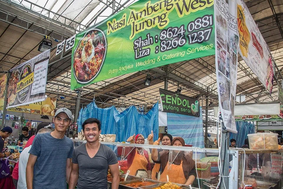 SAMBUTAN HANGAT: Walaupun gerai nasi ambeng Encik Sharulnizam (kanan) dibuka pada 2 petang setiap hari, pelanggan sudah mula beratur pada 1.30 petang.