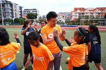 PERKASA KANAK-KANAK PEREMPUAN: Setiausaha Parlimen, Kementerian Kebudayaan, Masyarakat dan Belia, Encik Baey Yam Keng (tengah), bersama kanak-kanak di Stadium Serangoon semalam. - Foto SPORTCARES