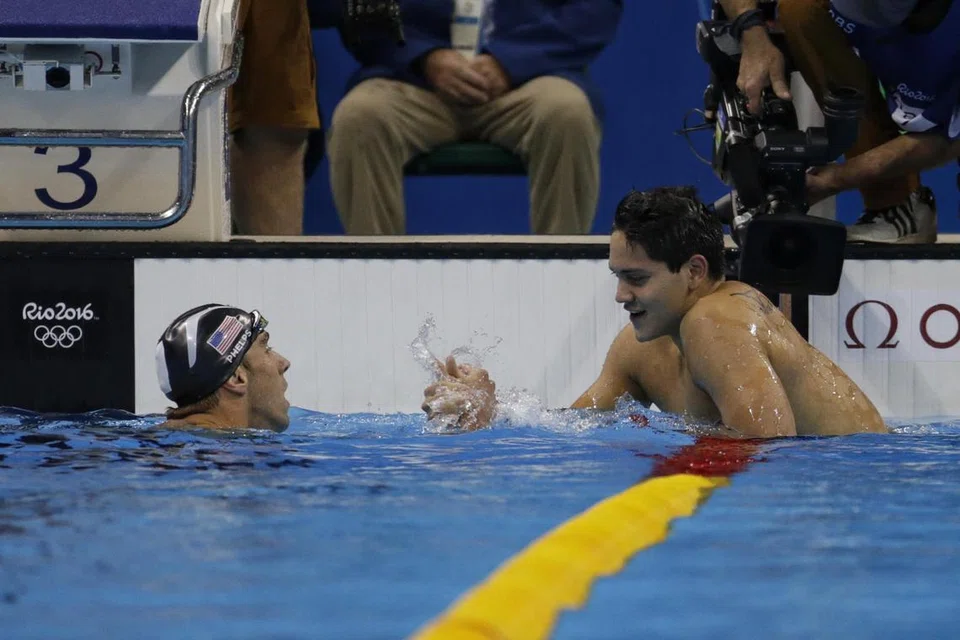Bintang renang Singapura, Joseph Schooling (kanan), menerima ucapan tahniah daripada Michael Phelps, selepas beliau memenangi acara renang kuak kupu-kupu 100 meter di Sukan Olimpik Rio pada 2016. 