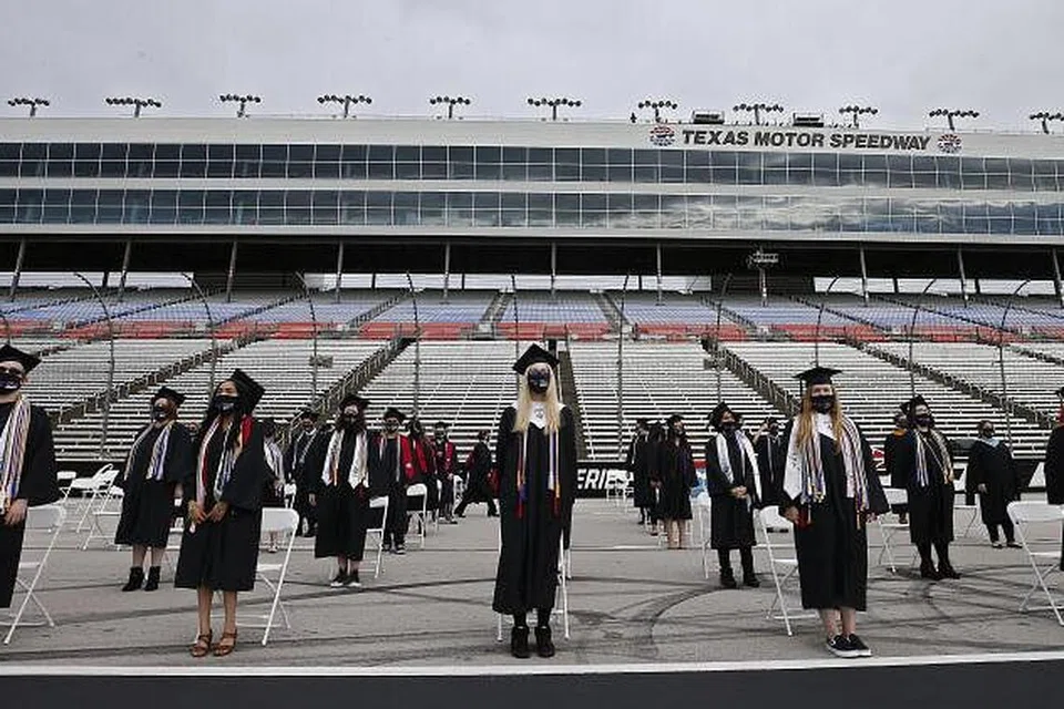 ACARA TAMAT SEKOLAH: Graduan Sekolah Tinggi Steele dilihat berpelitup dan mematuhi jarak selamat semasa menghadiri majlis tamat sekolah di litar lumba kereta, Texas Motor Speedway, di Dallas, Texas, kelmarin. Sekolah di metropleks Dallas-Fort Worth ini mengadakan acara di litar Speedway yang membolehkan keluarga menonton menerusi layar besar. 