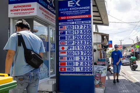 Orang ramai berjalan melepasi sebuah pengurup wang di Canggu, Bali, Indonesia pada 4 Jun 2026. Rupiah Indonesia jatuh ke paras terendah dalam sejarah berbanding dolar Amerika Syarikat ketika pembukaan pasaran pada 4 Jun 2026, mencecah 18,016 rupiah bagi setiap dolar AS.