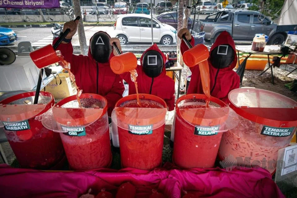 Peniaga jus tembikai pelbagai perisa, Cik Nur Nadira Muhamnad Nazir, 21 tahun, dan pasukannya memakai kostum siri popular Korea, ‘Squid Game’, untuk melariskan jus tembikai pelbagai perisa yang dijualnya di bazar Ramadan Meru Raya, Ipoh, Perak.