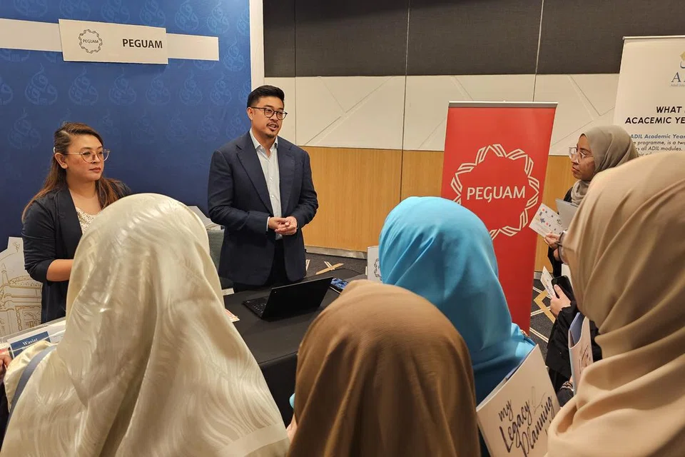 Rakan kongsi di Eldan Law LLP dan juga Pengerusi PEGUAM, Encik Imran Rahim (dua dari kiri), memberi pencerahan tentang usaha PEGUAM kepada para asatizah.