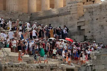 MENUNGGU DI TENGAH PANAS: Pelancong melawat Acropolis terpaksa menunggu dalam suasana panas apabila monumen Acropolis tutup buat sementara akibat cuaca panas di Athens, Greece. Kakitangan Palang Merah mengagihkan botol air sementara pelancong menunggu. 