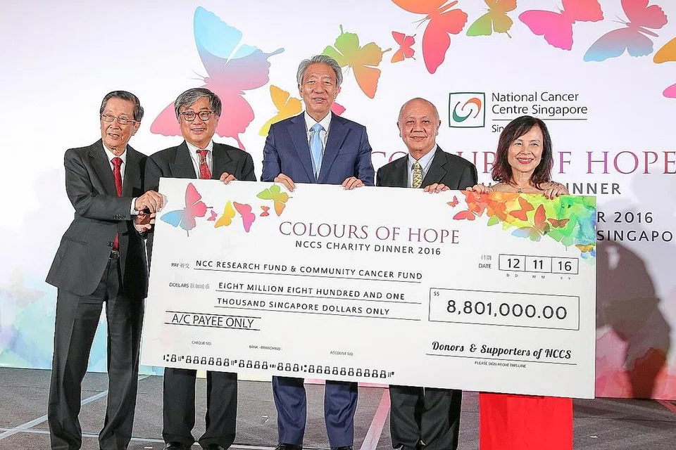 USAHA MELAWAN BARAH: Timbalan Perdana Menteri Teo Chee Hean (tengah) bersama cek sekitar $8.8 juta yang telah dikumpulkan NCCS dalam bentuk ikrar dan derma bagi penjagaan pesakit barah dan inisiatif kajian. Antara barang yang dilelong dan hasilnya didermakan untuk tujuan itu ialah tembikar yang dihasilkan Dr Iskandar Jalil yang dilelong pada harga $20,000. - Foto-foto SHAHIDA SARHID.