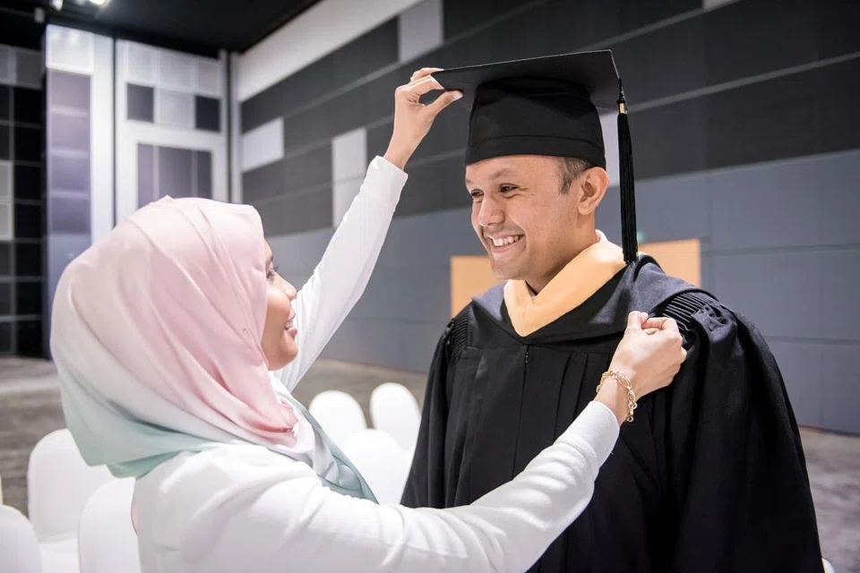 AKHIRNYA TERCAPAI HASRAT: Encik Muhammad Nazir berterima kasih kepada isteri Cik Mariani Jamil yang membantu menjaga anak mereka semasa beliau sibuk dengan pengajian. - Foto SMU