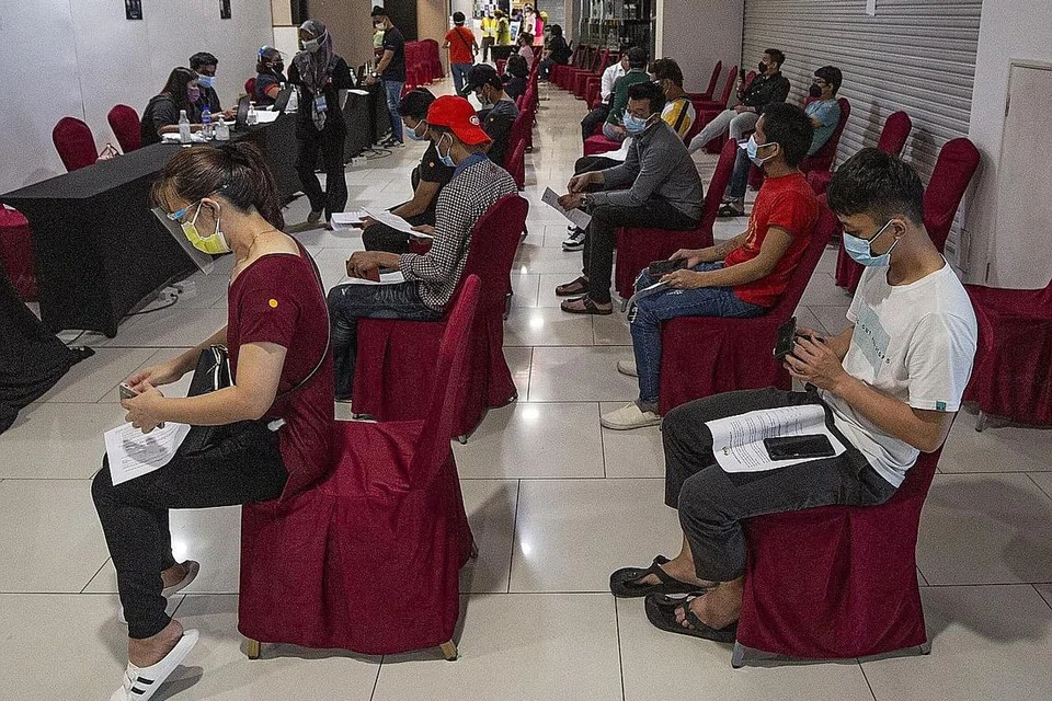 AMBIL VAKSIN: Beberapa penduduk Malaysia sedang menjalani pemeriksaan dokumen sebelum mendapatkan vaksin Covid-19 mereka di Kuala Lumpur. - Foto EPA-EFE