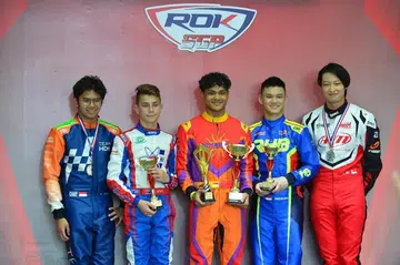 TEMPAT PERTAMA: Nooris Gafoor (tengah), yang telah berlumba dalam pelbagai pertandingan kereta ‘go-kart’, pernah menjuarai Piala Rok Asia 2023 Pusingan 2 dan Piala Rok Singapura 2023 Pusingan 3.