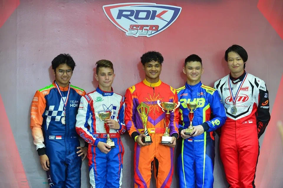 TEMPAT PERTAMA: Nooris Gafoor (tengah), yang telah berlumba dalam pelbagai pertandingan kereta ‘go-kart’, pernah menjuarai Piala Rok Asia 2023 Pusingan 2 dan Piala Rok Singapura 2023 Pusingan 3.