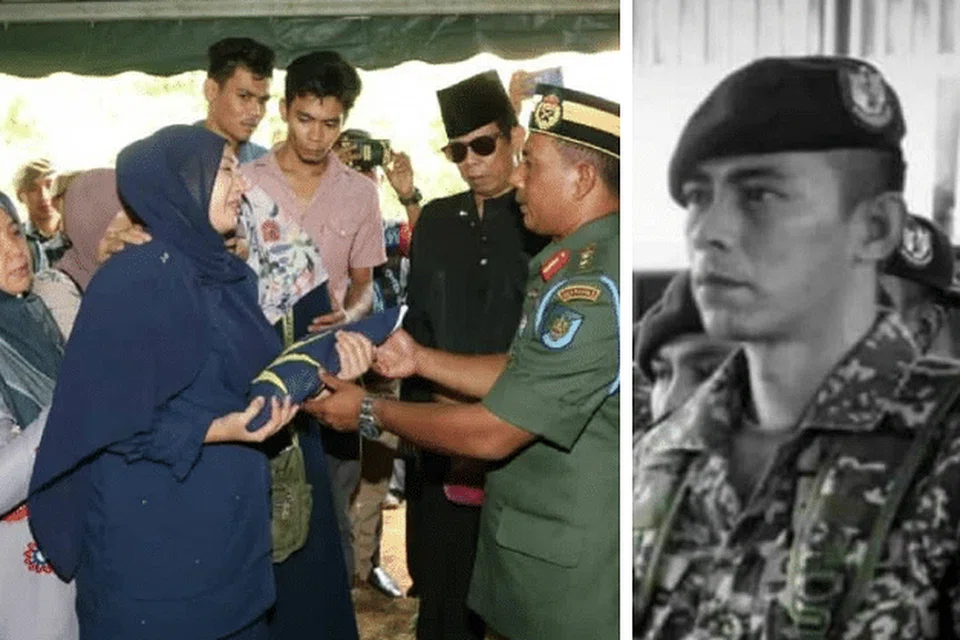 SELAMAT DIKEBUMIKAN: Isteri Almarhum Mejar Zahir (paling kanan), Cik Nour Shafinar Harun, menerima Jalur Gemilang daripada seorang askar semasa pengebumian suaminya di Tanah Perkuburan Tambun di Ipoh pada Khamis. -Foto MyMetro. 