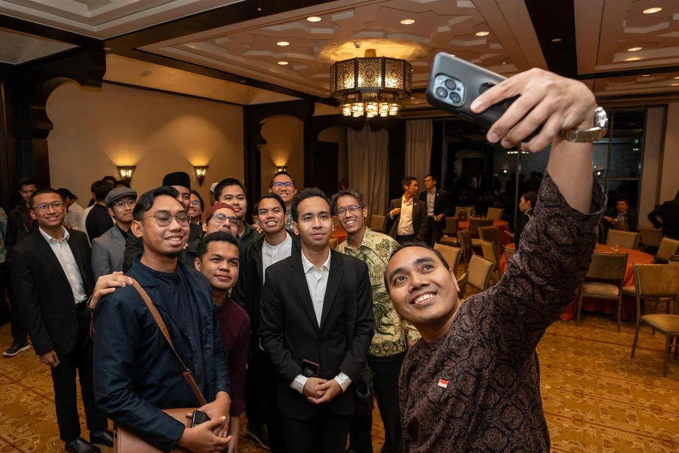 Anggota Parlimen, Encik Zhulkarnain Abdul Rahim (depan), dan AP Parti Pekerja (WP) Encik Gerald Giam (kanan, berbaju hijau), bergambar bersama pelajar Al-Azhar dari Singapura selepas majlis jamuan buka puasa pada 22 Mac.