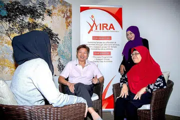 BANTU BEKAS PENAGIH: Cik Siti (berselendang hitam) bersembang bersama (dari kiri) Cik Ang, penyelaras program Wira, Cik Jihan Mohd Noor; dan Naib Presiden Wira, Cik Hamidah Johari. - Foto BH oleh ZALEHA ABDUL KADER