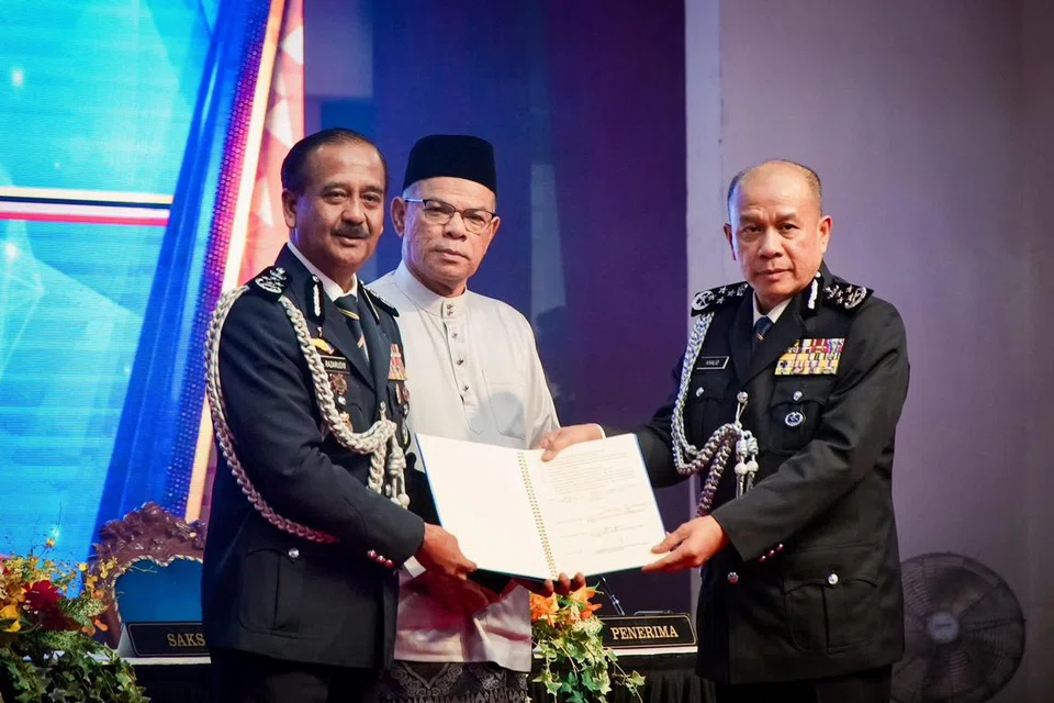 Bekas Ketua Polis Malaysia, Tan Sri Razarudin Husain (kiri), menyerahkan tongkat kuasa kepada Ketua Polis Malaysia yang baru, Datuk Seri Mohd Khalid Ismail (kanan), disaksikan Menteri Dalam Negeri, Datuk Seri Saifuddin Nasution Ismail (tengah), pada Majlis serah tugas di Pusat Latihan Polis (Pulapol), Kuala Lumpur pada 20 Jun.