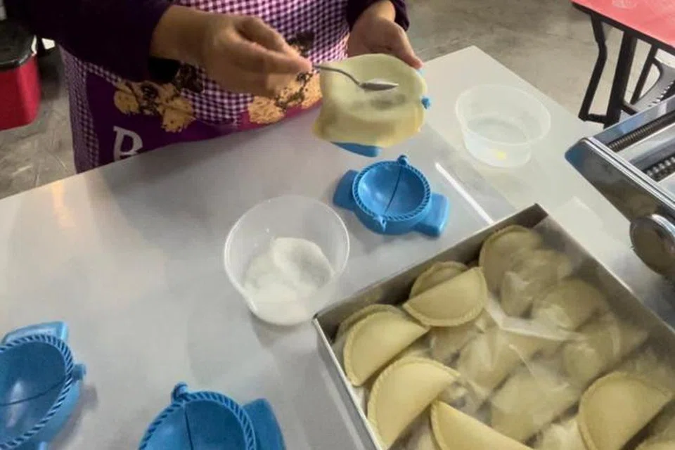 BERI RASA: Cik Norhayu Mohd Noor, peniaga epok-epok inti oksigen yang tular di Batu Caves, Selangor, meletakkan sedikit gula ke dalam acuan epok-epok untuk memberikan rasa epok-epok yang lebih lemak. 