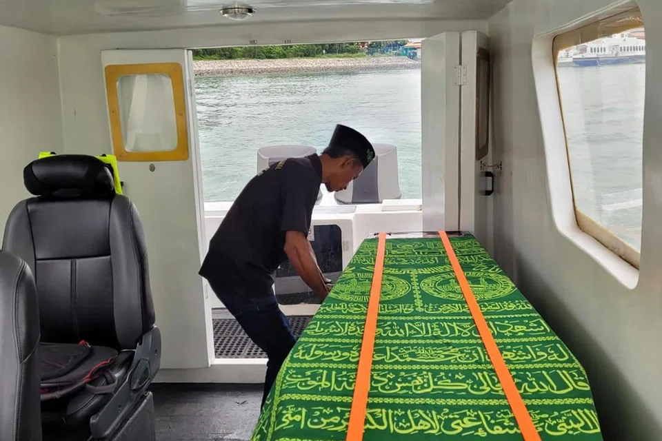 PASTIKAN SELAMAT: Seorang kru bot laju milik syarikat Md Akbar International Batam memastikan keranda diikat dengan selamat sebelum memulakan perjalanan. Bot laju itu boleh menampung satu jenazah dan seorang kapten serta tiga kru pada satu-satu masa.