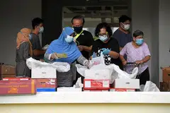 TIADA PEMBAZIRAN: (Gambar atas) Inisiatif Food Rescue Sengkang mengagihkan buah-buahan yang diselamatkan dari Pusat Borong Pasir Panjang kepada penduduk di Fernvale. - Foto fail