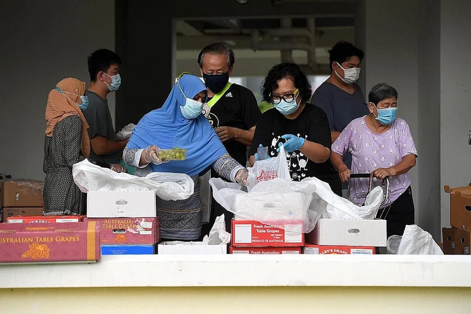 TIADA PEMBAZIRAN: (Gambar atas) Inisiatif Food Rescue Sengkang mengagihkan buah-buahan yang diselamatkan dari Pusat Borong Pasir Panjang kepada penduduk di Fernvale. - Foto fail