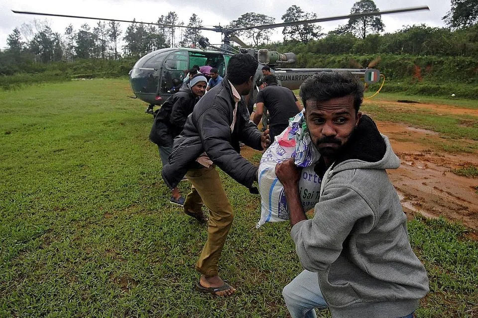 BANTUAN DIAGIH: Mangsa banjir menerima bantuan kemanusian yang dihantar dengan helikopter Angkatan Udara India di Kampung Nelliyampathy, di Kerala. - Foto REUTERS