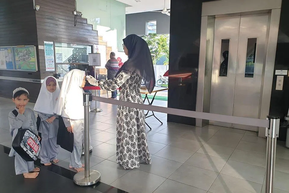 TANGGUNGJAWAB PERIBADI: Pelajar program aLIVE di Masjid Assyafaah ini perlu menjalani pemeriksaan suhu badan sebelum kelas bermula.