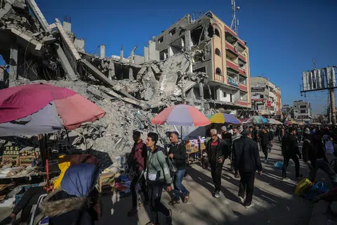Para penduduk Palestin berkunjung ke gerai yang didirikan bersebelahan bangunan-bangunan yang runtuh dekat kem pelarian Nuseirat pada 11 Mac.