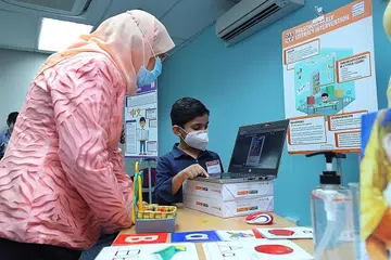 MENDEKATI MASYARAKAT: Presiden Halimah Yacob beramah tamah dengan Karn, 6 tahun, seorang pelajar yang menjalani program DAS Prasekolah semasa lawatannya ke pusat DAS semalam. - Foto MCI