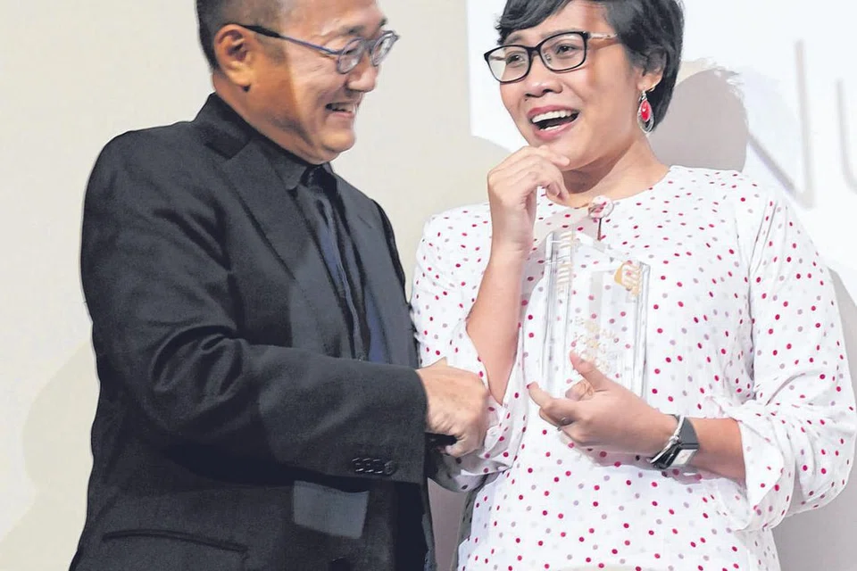 TERKEJUT: Cik Nuraliah Norasid, yang terkejut dengan kemenangannya, menerima ucapan tahniah daripada pengasas Epigram Books, Encik Edmund Wee. - Foto THE STRAITS TIMES