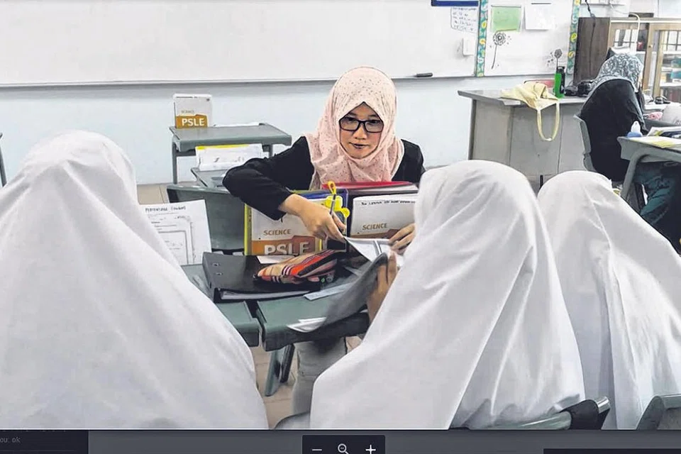 BERJINAK-JINAK MENGAJAR: Cik Insyirah (menghadap kamera) menyemai minat dalam mengajar sejak kecil lagi. Dengan menyertai program AAM di Madrasah Alsagoff, beliau berpeluang mengalami kehidupan sebagai seorang guru dan menggilap kemahiran dan nilai dalam bidang pengajaran.