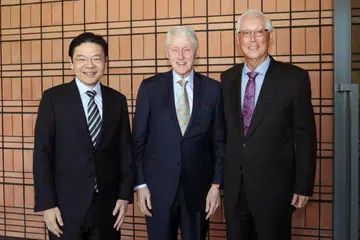 Perdana Menteri, Encik Lawrence Wong (kiri), dan Menteri Kanan Emeritus (ESM), Encik Goh Chok Tong (kanan), bersama mantan Presiden Amerika Syarikat, Encik Bill Clinton, pada 21 Mei.