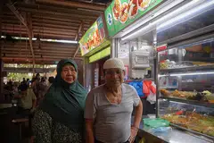 PERNIAGAAN TURUN-TEMURUN: Cik Azizah Abdullah, yang kini dibantu suaminya, Encik Abdul Karim, dan pekerja lain merancang menyerahkan gerainya di Pusat Makanan Ghim Moh kepada cucunya kelak. - Foto BM oleh MARK CHEONG
