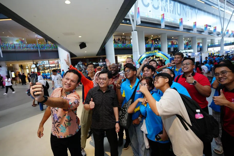 Menteri Negara Kanan (Pertahanan merangkap Tenaga Manusia), Encik Zaqy Mohamad, (kiri) dan Timbalan Perdana Menteri, Encik Heng Swee Keat (dua dari kiri) berswafoto bersama pelajar yang menyertai Tuisyen Mendaki (MTP) yang hadir ketika acara pelancaran Raikan Ilmu@Heartlands 2024 di Our Tampines Hub (OTH) pada 29 Jun. 