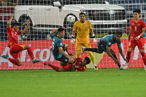 Benteng pertahanan Singapura mempamerkan semangat juang yang tinggi apabila menentang Vietnam di Stadium Kebangsaan My Dinh pada 31 Julai. Barisan pertahanan Singa, diketuai oleh pemain berpengalaman seperti Hariss Harun (dua dari kanan) dan penjaga gawang, Izwan Mahbud (tiga dari kanan), mempamerkan prestasi baik untuk mengikat Vietnam 0-0 dalam aksi Piala Asean Hyundai itu.