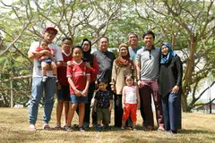 MASA DEPAN TERJAGA: Pasangan Generasi Merdeka, Cik Juhana (empat dari kanan) dan suami, Encik Sarnin (sebelahnya), yang bergambar bersama anak dan cucu mereka, yakin sokongan tambahan pemerintah membolehkan mereka dapat terus hidup berdikari. - Foto BH oleh SAHIBA CHAWDHARY