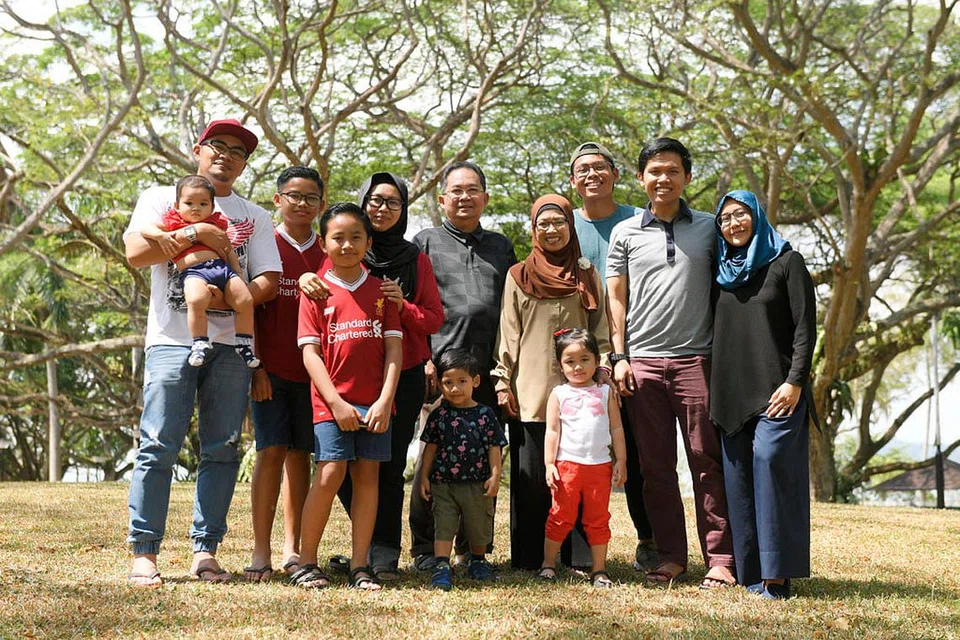 MASA DEPAN TERJAGA: Pasangan Generasi Merdeka, Cik Juhana (empat dari kanan) dan suami, Encik Sarnin (sebelahnya), yang bergambar bersama anak dan cucu mereka, yakin sokongan tambahan pemerintah membolehkan mereka dapat terus hidup berdikari. - Foto BH oleh SAHIBA CHAWDHARY