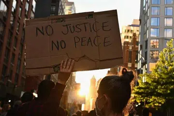 KEBIMBANGAN RAMAI: Seorang penunjuk perasaan di New York mengangkat sepanduk semasa tunjuk perasaan "Black Lives Matter" susulan kematian seorang warga berkulit hitam, Encik George Floyd, semasa ditahan sepasukan empat anggota polis di Minneapolis, pada 25 Mei lalu. Mayor New York, Encik Bill de Blasio, hari ini mengisytiharkan perintah berkurung dari 11 malam hingga 5 pagi bagi menghentikan keganasan yang berpunca dari tunjuk perasaan yang dijalankan secara aman. 