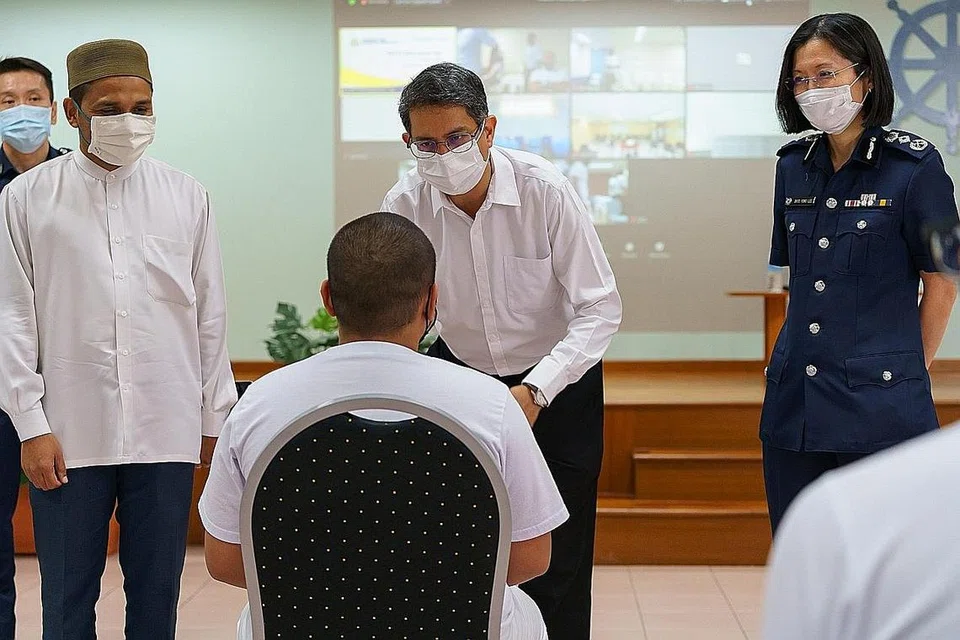DEKATI PESALAH: Dr Nazirudin (paling kiri) dan Dr Faishal (tengah) berinteraksi dengan seorang banduan setelah ceramah motivasi yang diadakan di Institusi TM1 di Pusat Tanah Merah semalam. - Foto SPS
