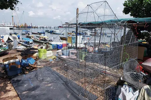 SUDAH SIAP: Beberapa bubu yang telah disiapkan Encik Hamzah Mohamad menunggu masa untuk dikerahkan ke laut. 