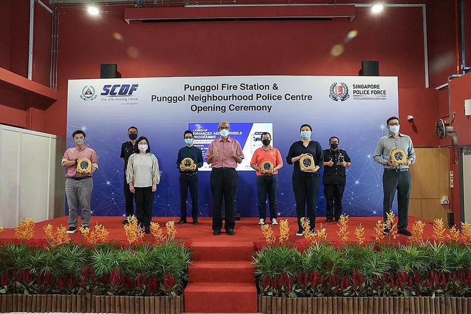 LENGKAP KERETA DENGAN AED: Pengarah lembaga Temasek Foundation Cares Encik Zainul Abidin Rasheed (barisan depan, tengah) dan pengarah Jabatan Sukarelawan dan Kerjasama Masyarakat di SCDF, Penolong Pesuruhjaya (AC) Yazid Abdullah (barisan belakang, kiri) bersama peserta pemandu yang meletakkan AED dalam kereta mereka. - Foto SCDF