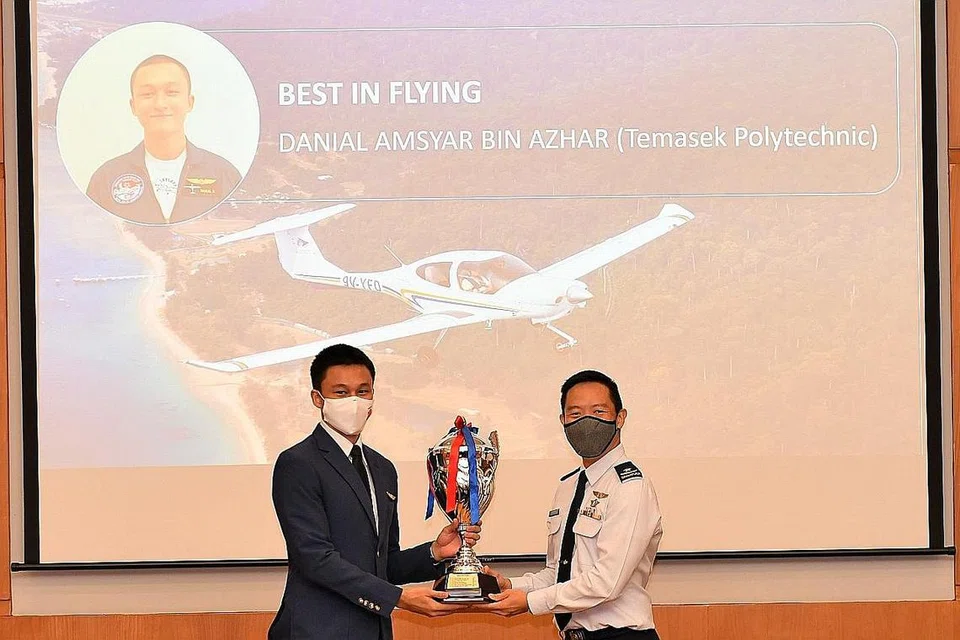 MENCAPAI CITA-CITA TINGGI: OCT Danial Amsyar Azhar (kiri) menerima Anugerah Terbaik dalam Penerbangan oleh Presiden Jawatankuasa Pengurusan SYFC, Brigadier-Jeneral Kelvin Fan Sui Siong sewaktu majlis penyampaian anugerah semalam. - Foto SYFC