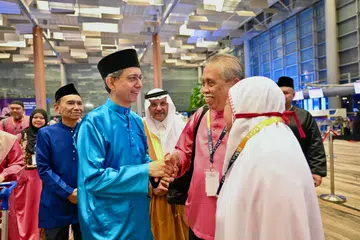 Pemangku Menteri Bertanggungjawab bagi Ehwal Masyarakat Islam, Profesor Madya Dr Muhammad Faishal Ibrahim (dua dari kiri), beramah-tamah dengan anggota jemaah yang bakal menunaikan ibadah haji di Terminal 3 Lapangan Terbang Changi pada 13 Mei. Beliau ditemani Presiden Majlis Ugama Islam Singapura (Muis), Encik Mohamed Saat Abdul Rahman (kiri) dan Duta Kerajaan Arab Saudi ke Singapura, Encik Mohammad Abdullah S. Al Ghamdi (tengah).