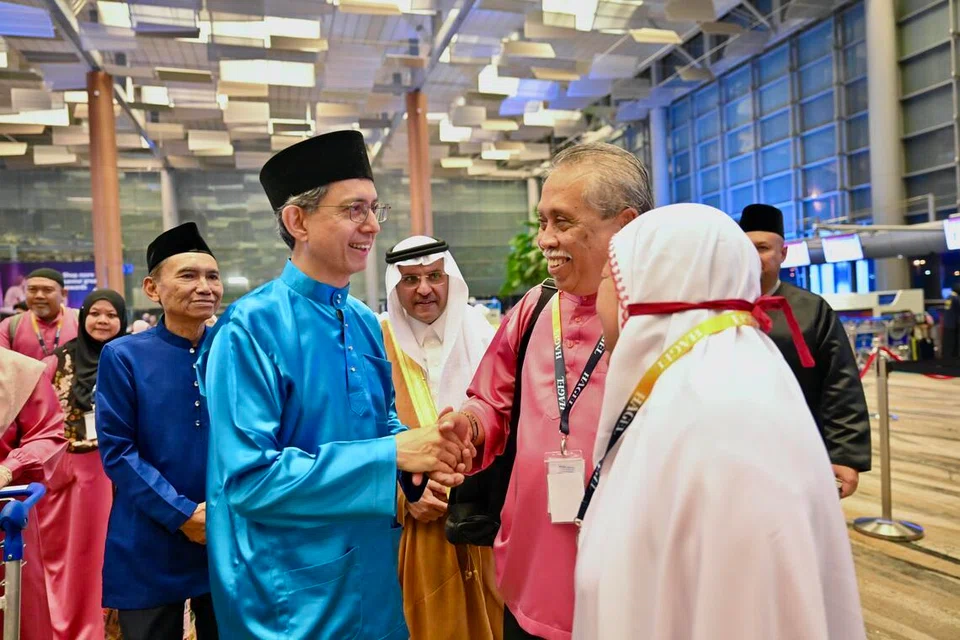 Pemangku Menteri Bertanggungjawab bagi Ehwal Masyarakat Islam, Profesor Madya Dr Muhammad Faishal Ibrahim (dua dari kiri), beramah-tamah dengan anggota jemaah yang bakal menunaikan ibadah haji di Terminal 3 Lapangan Terbang Changi pada 13 Mei. Beliau ditemani Presiden Majlis Ugama Islam Singapura (Muis), Encik Mohamed Saat Abdul Rahman (kiri) dan Duta Kerajaan Arab Saudi ke Singapura, Encik Mohammad Abdullah S. Al Ghamdi (tengah).