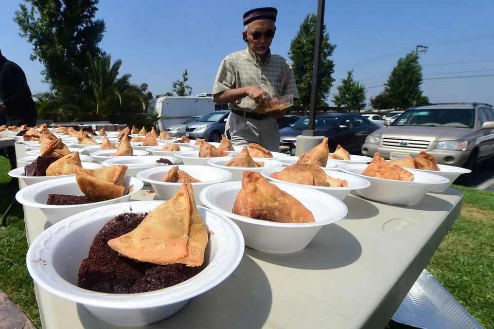DI CALIFORNIA: Encik Arshad Farooq membantu menyediakan juadah untuk Aidilfitri termasuk samosa dan kek coklat di Masjid Baitul Hameed in Chino, California. - Foto AFP