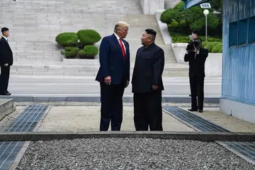 CIPTA SEJARAH: Presiden Donald Trump (kiri) menjadi presiden Amerika pertama menjejakkan kaki di Korea Utara, semalam. Beliau bertemu pemimpin negara itu, Kim Jong Un. - Foto AFP