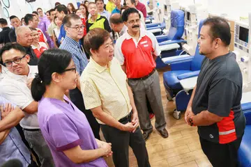 PUSAT DIALISIS TERBARU: Encik Khaw beramah mesra dengan pesakit, Encik Mohamad Nizam Mohamad Dorah (kanan) selepas merasmikan pembukaan rasmi cawangan Pusat Dialisis The Hour Glass-NKF di Admiralty, semalam. - Foto ZAOBAO.